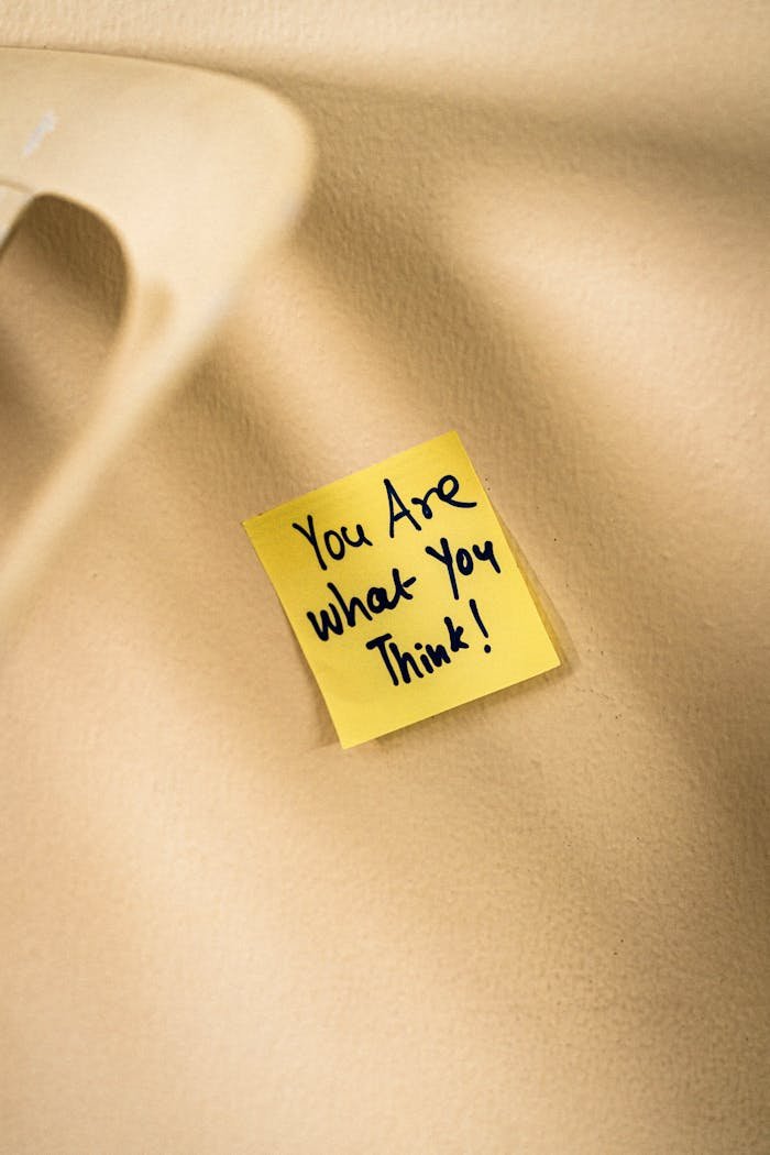 Yellow sticky note with motivational message on beige surface.