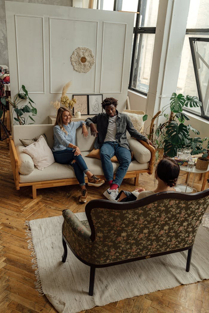 A couple in a counseling session with a therapist in a stylish, well-lit loft space.