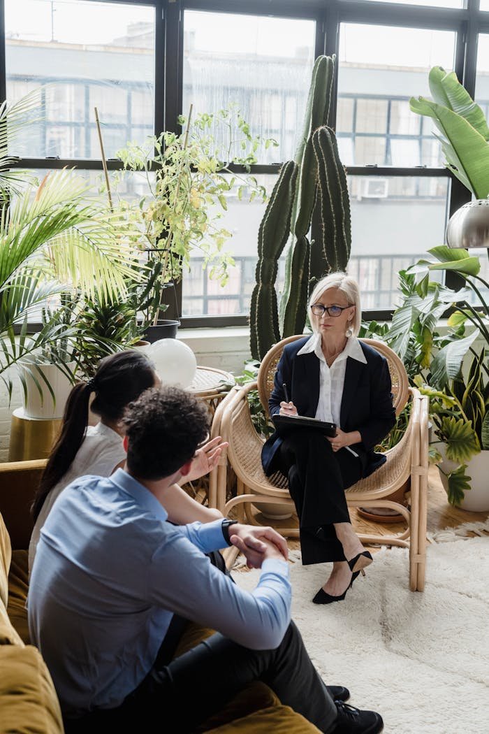 A couple attends a psychotherapy session with a psychotherapist in an indoor setting.